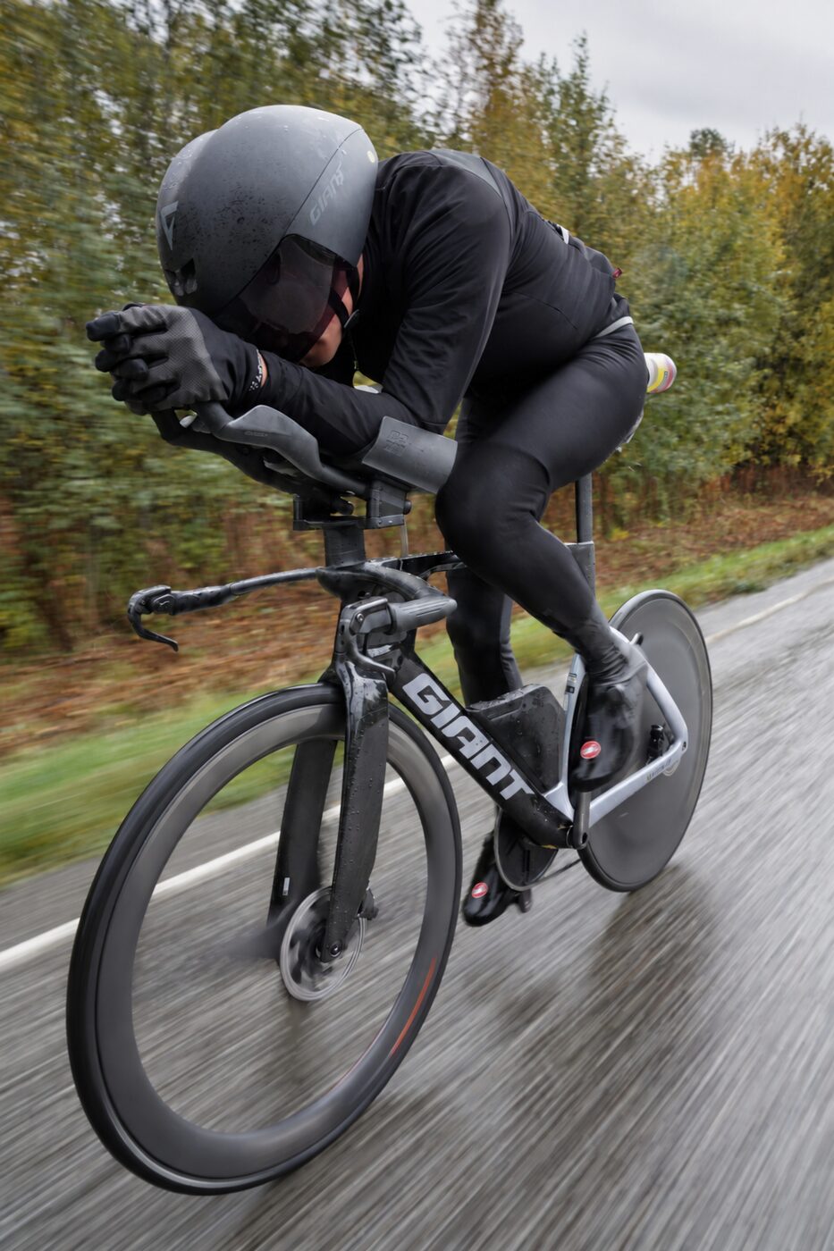 Sigurd riding hard in the rain on an autumn road, tucked low over the aero bars